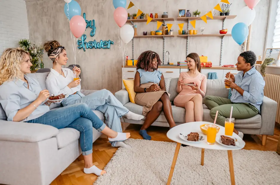 Beautiful young pregnant black woman having a baby shower with friends at home.