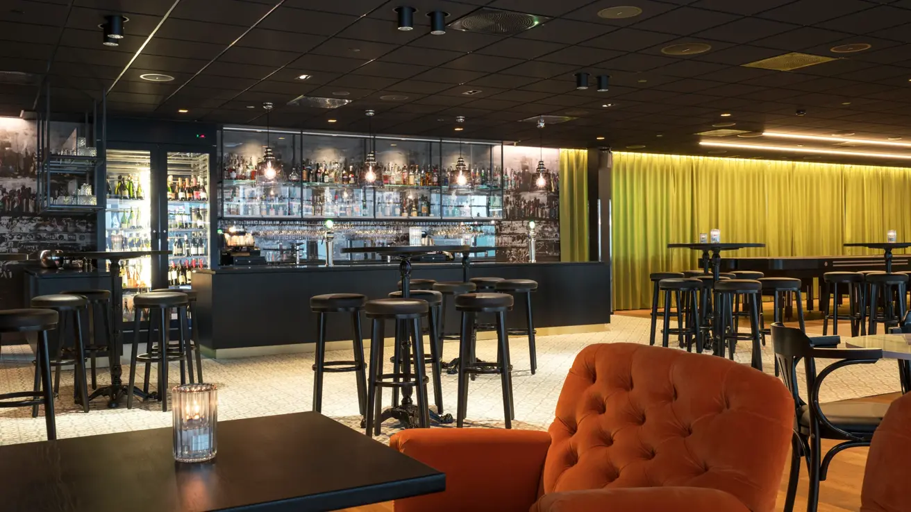 Store orange lenestoler og enkle spisebord  på Thon Hotel Oslo Airport ved Gardermoen