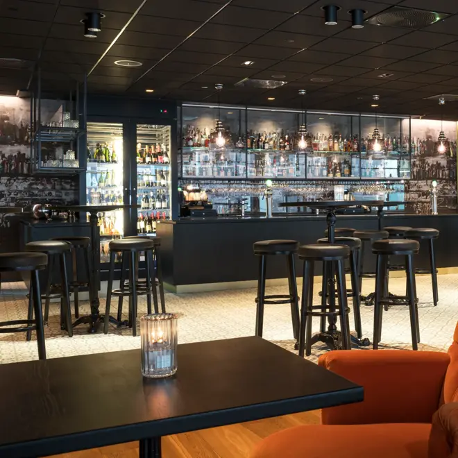 Store orange lenestoler og enkle spisebord  på Thon Hotel Oslo Airport ved Gardermoen