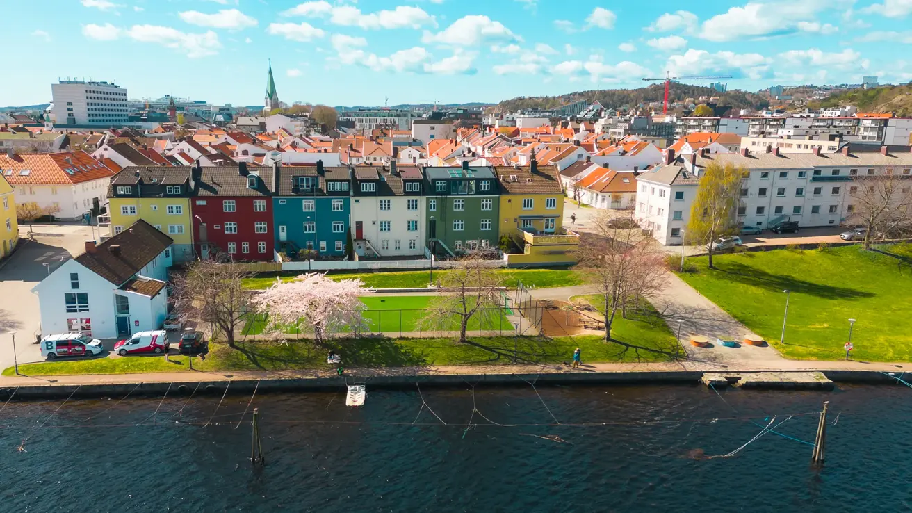 Vår i Elvegata, med fargerike bygninger, og Kristiansand sentrum i bakgrunnen.
