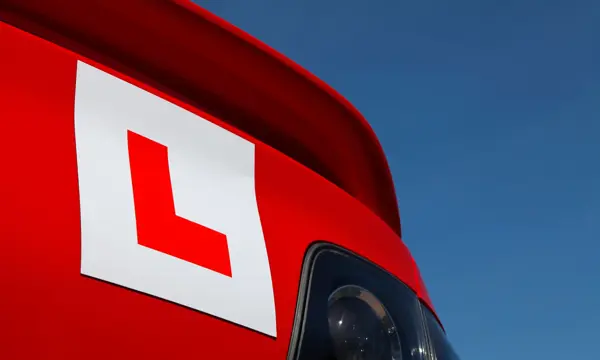 Learner Plate on Rear of Red Car looking up towards sky