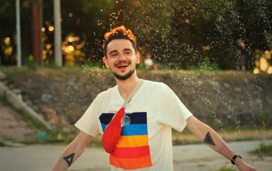 Mann med fargerik t-skjorte med trykk danser på gaten