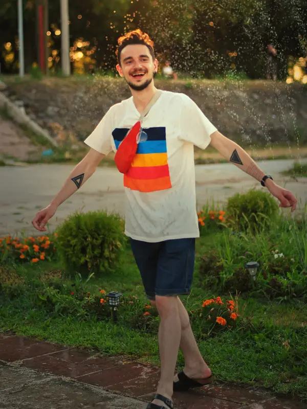 Mann med fargerik t-skjorte med trykk danser på gaten