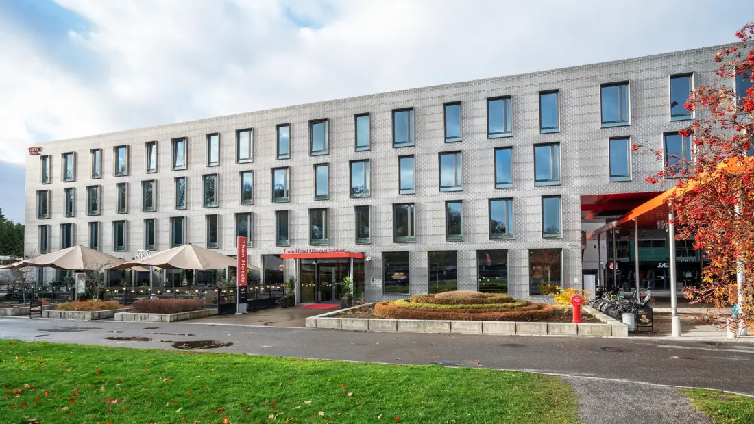 Fasade av Thon Partner Hotel Ullevål Stadion med gressplen i forgrunnen