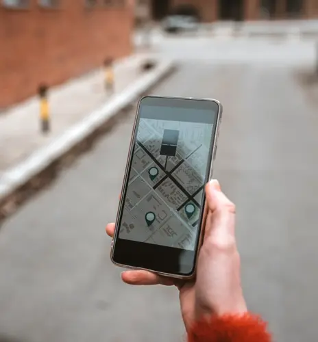 Photo of Tourist, Unrecognizable Person using map in phone app to navigate and find location of hotel in city during the day. Woman with smartphone using GPS service. Travel and navigation concept. Rear view of Caucasian woman walking in the street using her mobile phone with copy space.