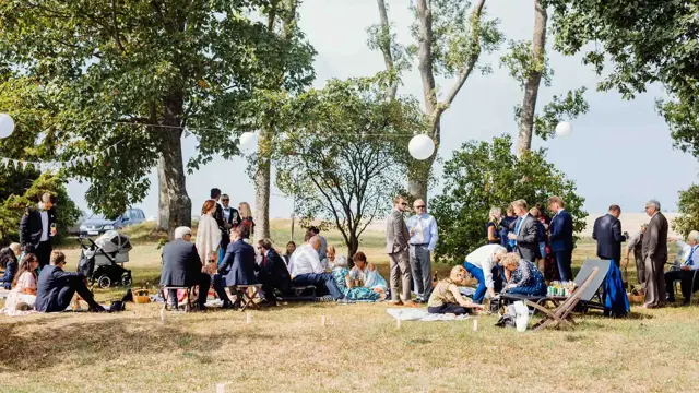 Sommerlig kledde bryllupsgjester har piknik