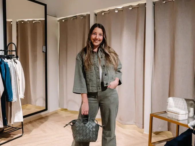 dame i vårklær står ved prøverom