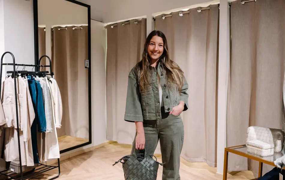 dame i vårklær står ved prøverom