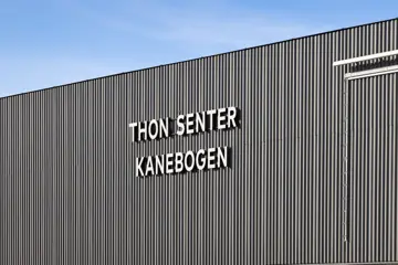 Fasadebilde av kjøpesenteret Thon Senter Kanebogen med Thon Senter logo.