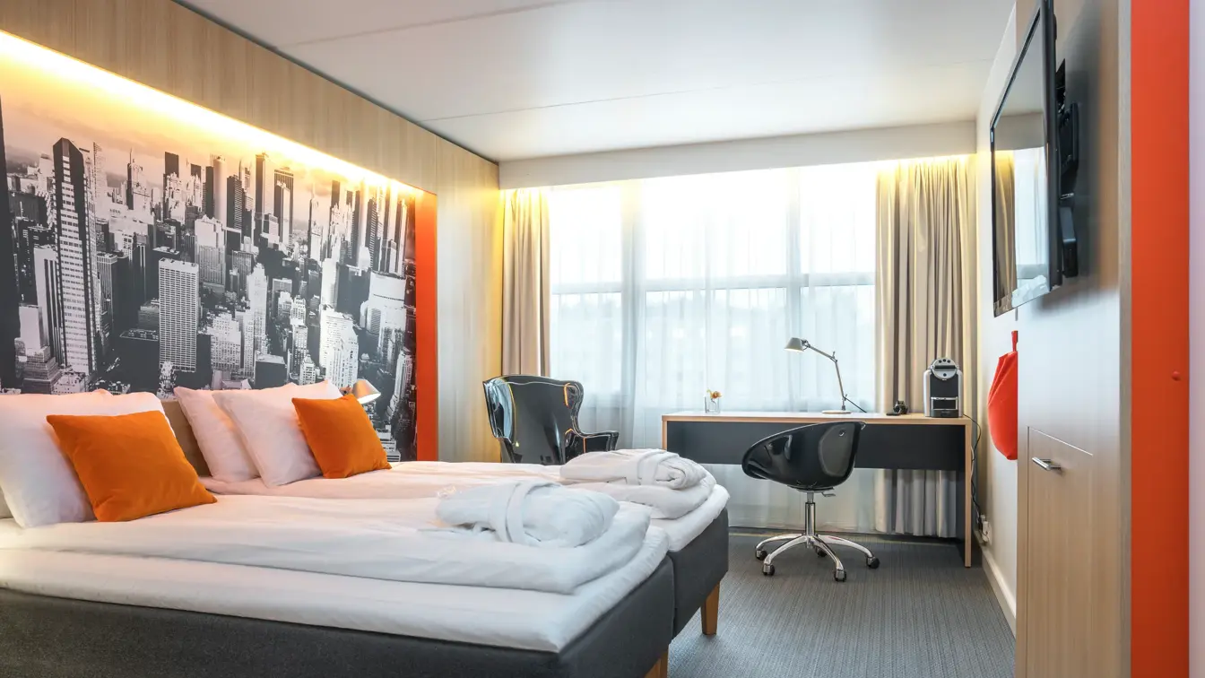 Dobbeltseng og skrivebord i superior room på Thon Hotel Bergen Airport