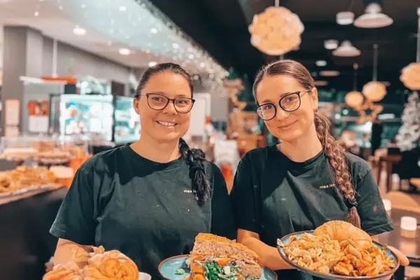 To damer holder frem fat med fristende retter fra Moa Lets eat