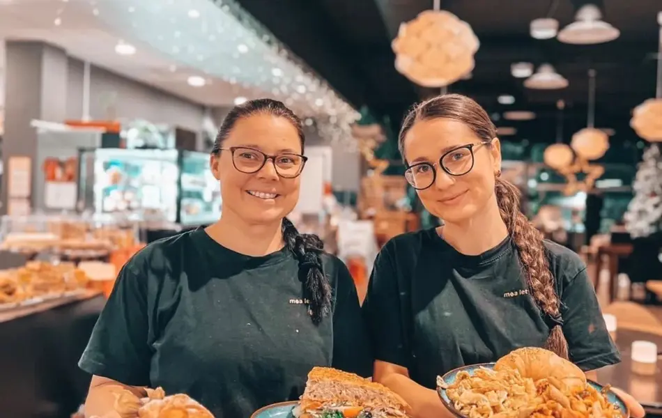 To damer holder frem fat med fristende retter fra Moa Lets eat