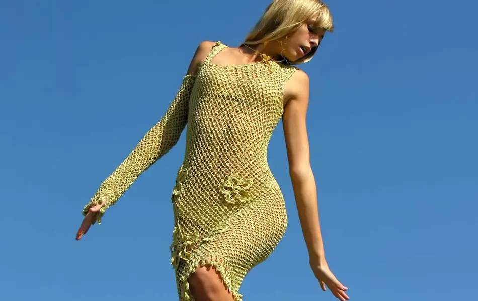 dame som poserer i grønn heklet kjole