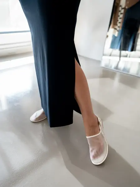 Damemodell med sort langt skjørt og hvite sandaler