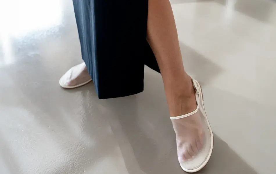 Damemodell med sort langt skjørt og hvite sandaler