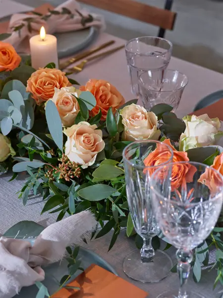 Dekorert bord til bryllup med oransje blomster
