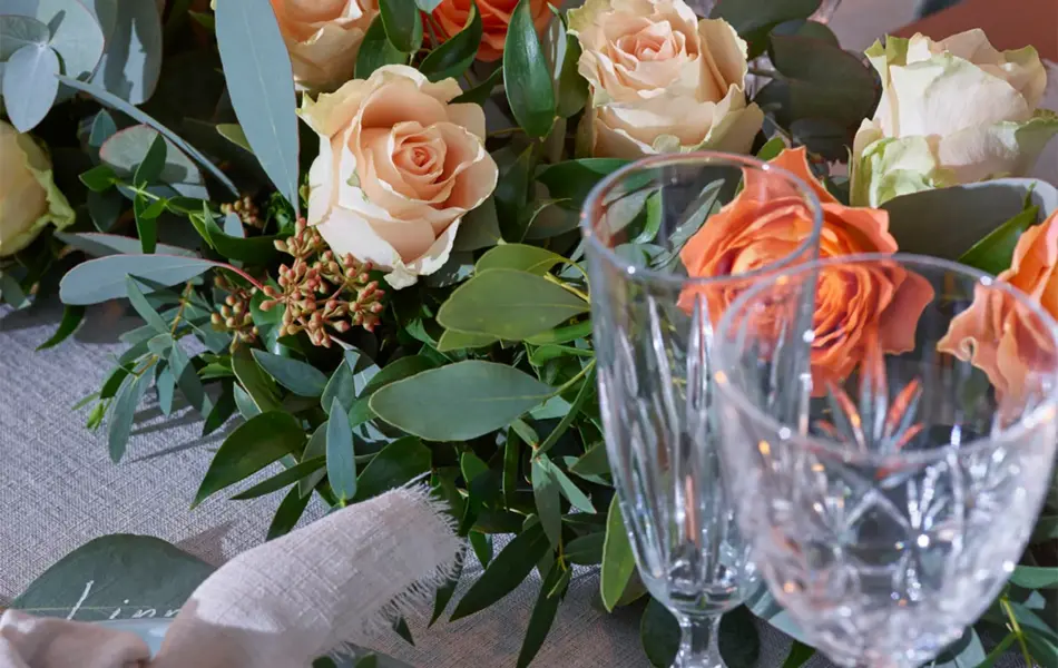 Dekorert bord til bryllup med oransje blomster