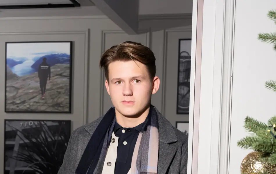 Gutt som lener seg mot en vegg