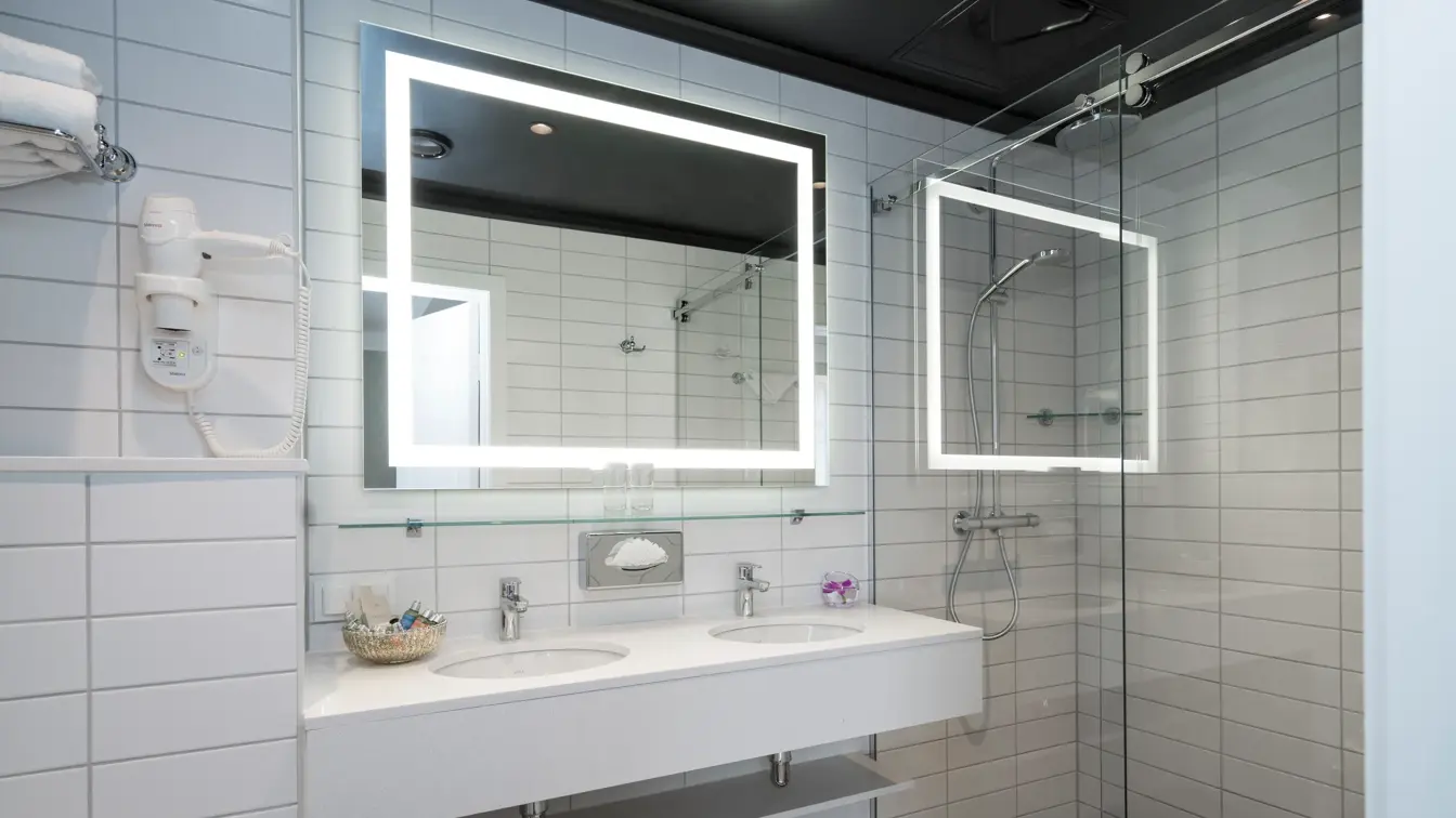 Bad med vask, stort speil og dusj på suite på Hotel Bristol i Oslo sentrum