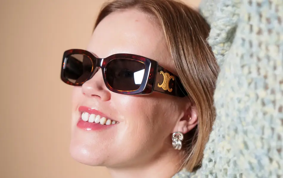 Dame med brune Celine solbriller med gull-logo på siden