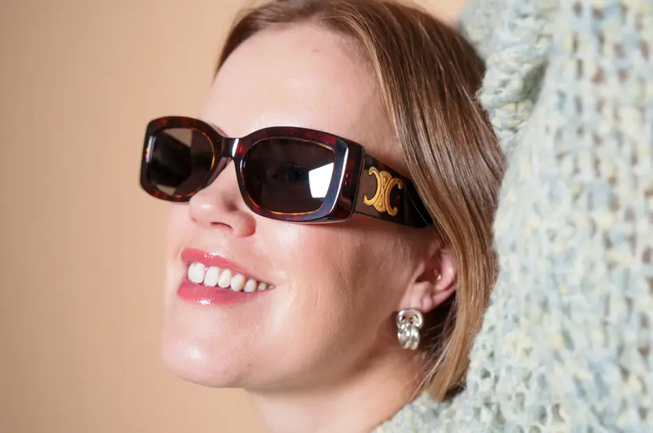 Dame med brune Celine solbriller med gull-logo på siden