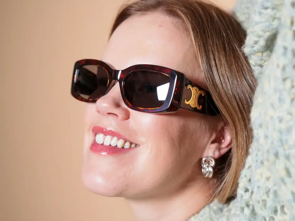 Dame med brune Celine solbriller med gull-logo på siden
