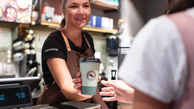 Espressohouse dame leverer kaffe til kunde
