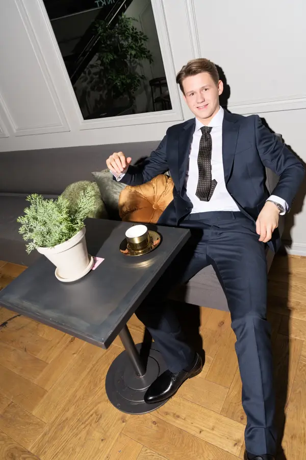 Gutt i blå dress som sitter ved et bord