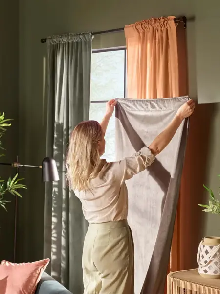 Dame som måler opp en gardin