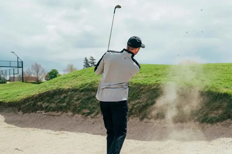 Mann som spiller golf