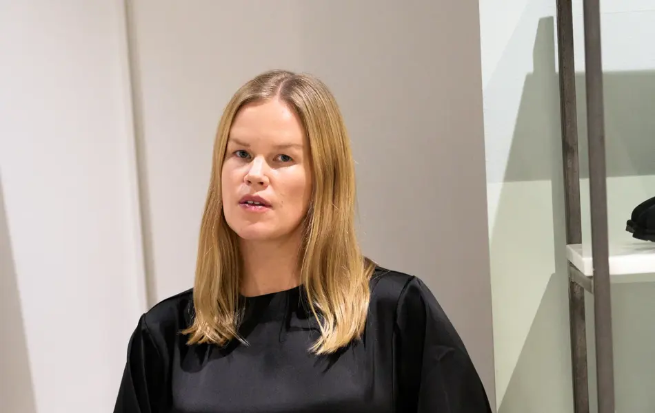 Dame med sort blank kjole og liten leopardveske.