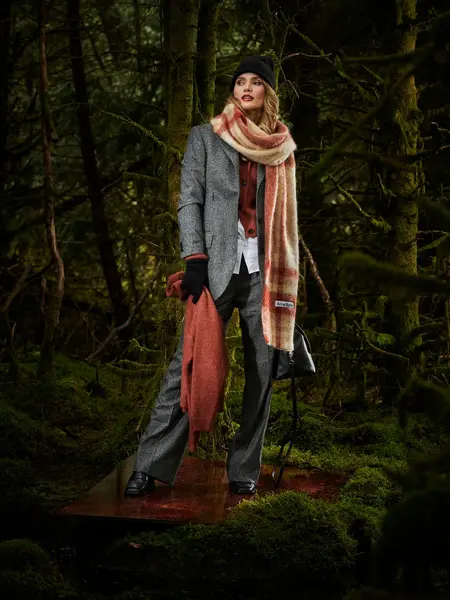 Dame i grå dress i skogen