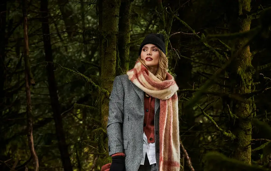 Dame i grå dress i skogen