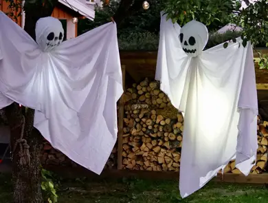 Hjemmelaget spøkelser av laken som henger fra trær
