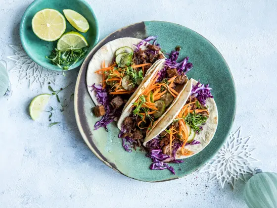 Taco på et fat med lime i en skål ved siden av