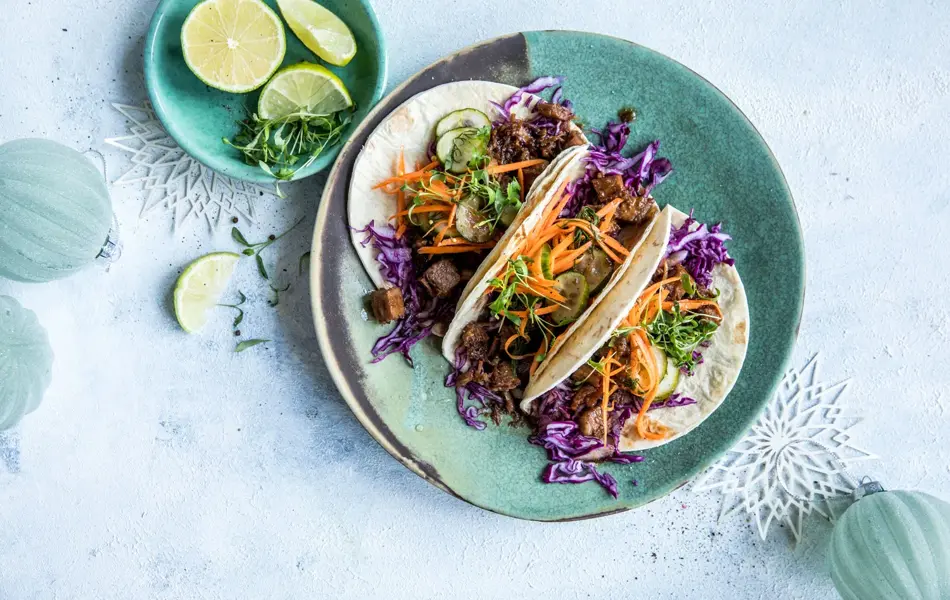 Taco på et fat med lime i en skål ved siden av