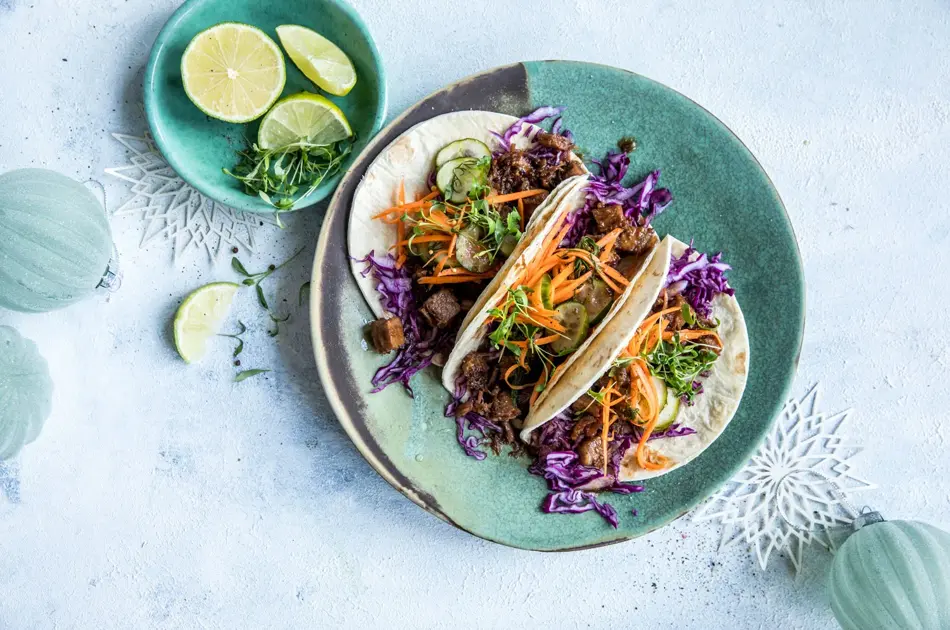 Taco på et fat med lime i en skål ved siden av
