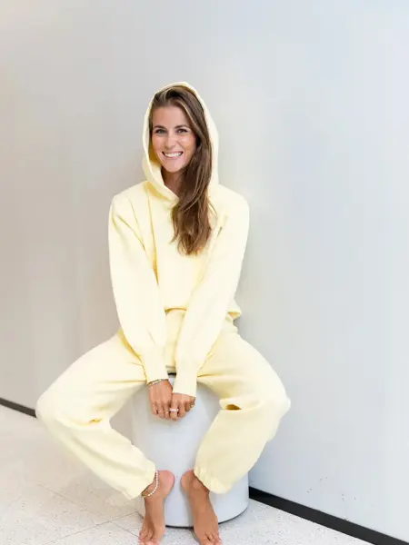 Ung kvinne på en krakk kledd i lysegul joggedress