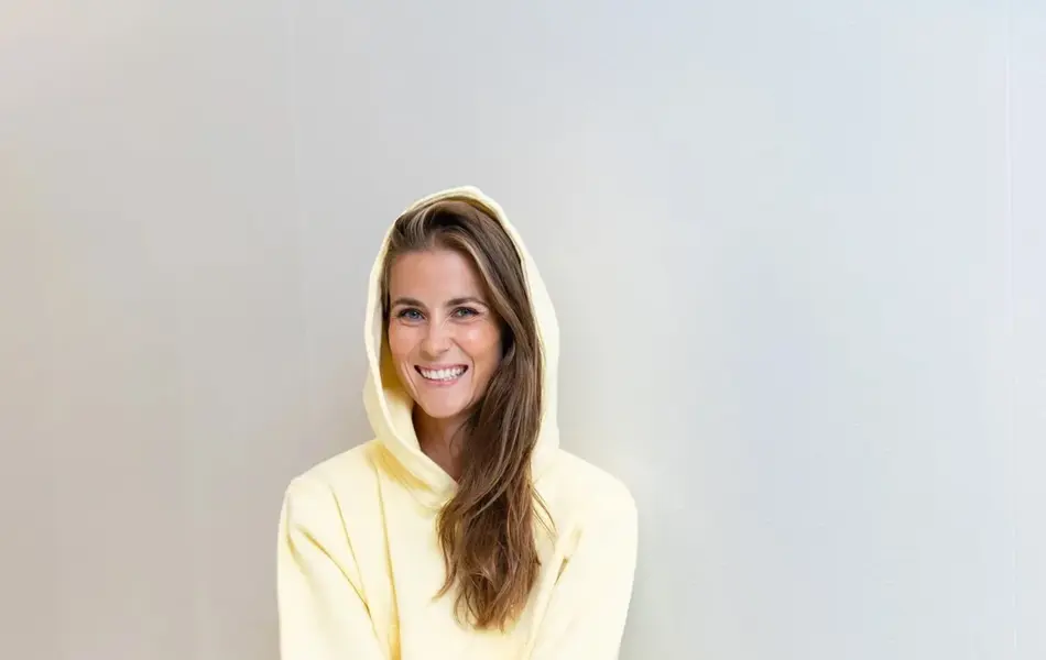 Ung kvinne på en krakk kledd i lysegul joggedress