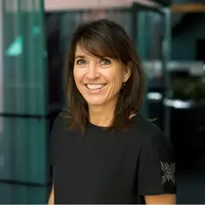 Nicole Dybwad Emblem poserer i et halvmørkt rom med uskarp bakgrunn