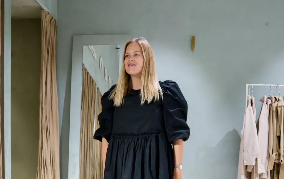 Jente med blondt hår, har på seg en lang sort kjole