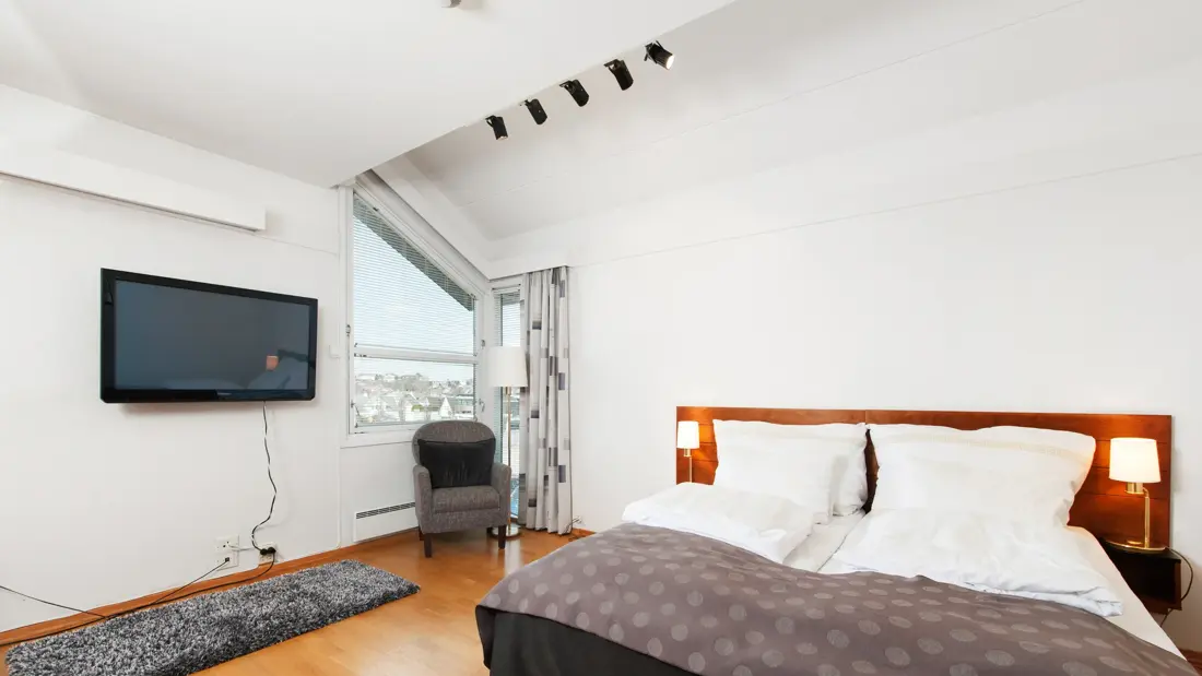 Rom med dobbeltseng, vindu, tv og stol i Superior Room hos Thon Hotel Sandnes