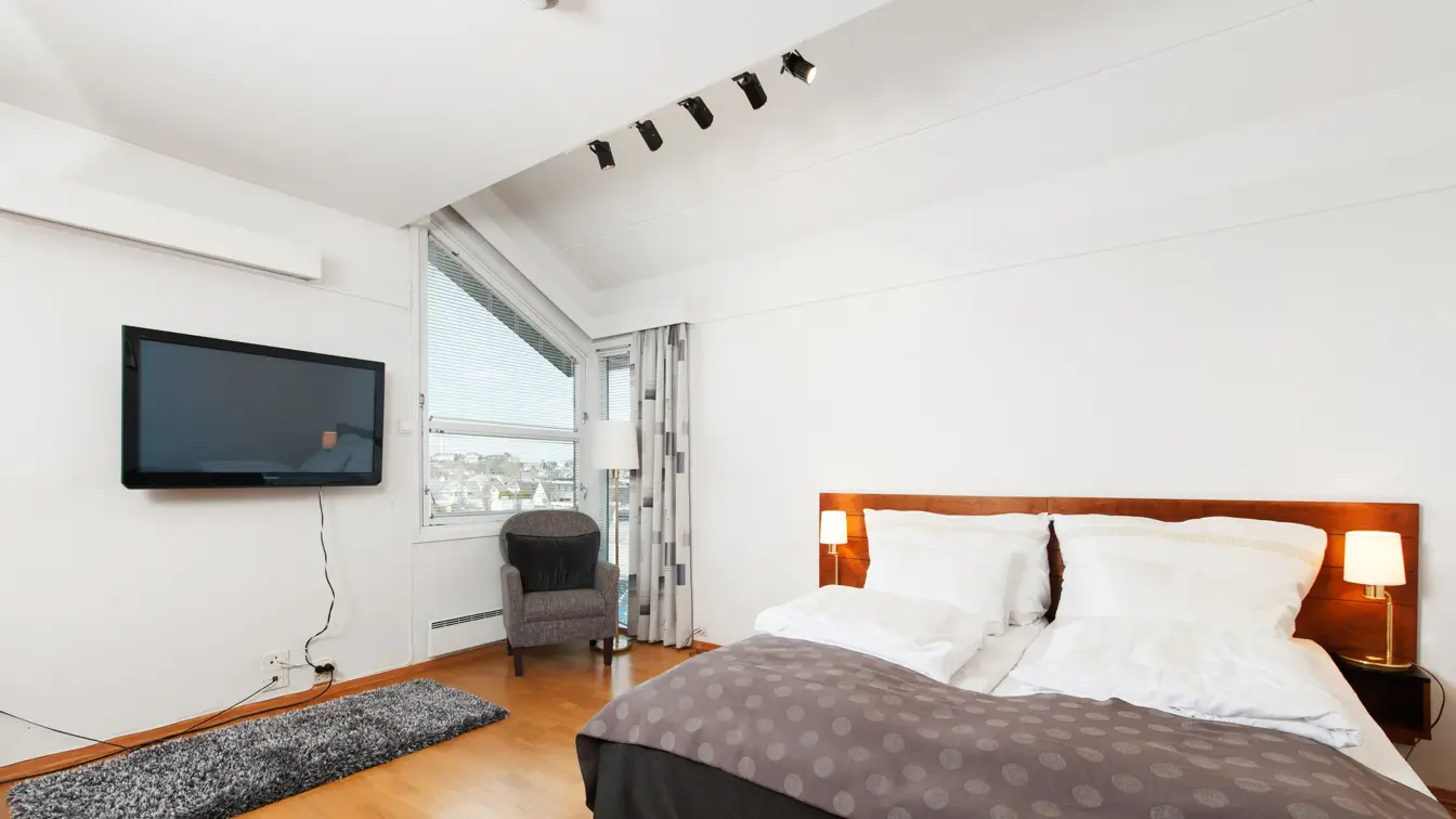 Rom med dobbeltseng, vindu, tv og stol i Superior Room hos Thon Hotel Sandnes