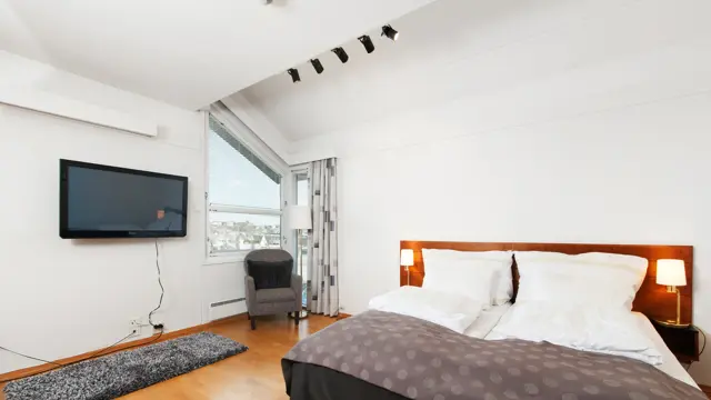 Rom med dobbeltseng, vindu, tv og stol i Superior Room hos Thon Hotel Sandnes