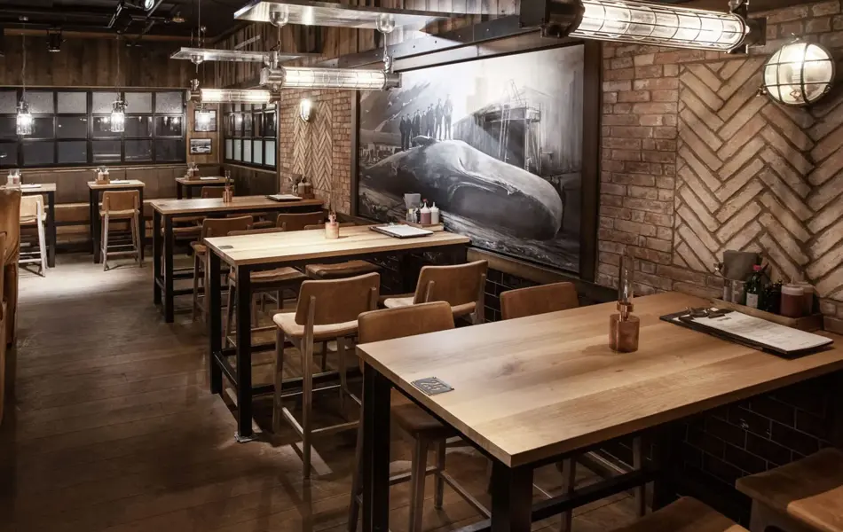 restaurant med flere sitteplasser av tre og et stort maleri med hval