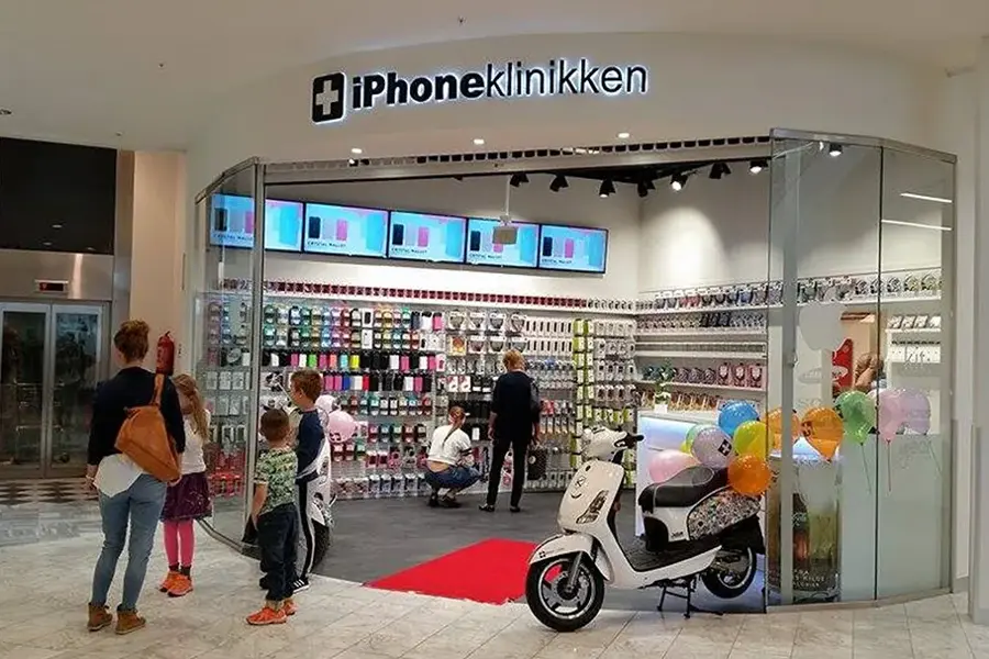 barn og foreldre som står ved inngangen til butikken