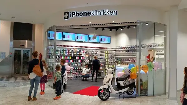 barn og foreldre som står ved inngangen til butikken