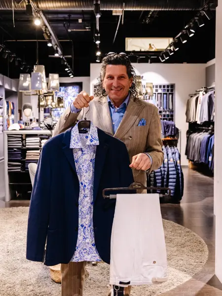 mann holder frem klær