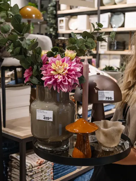 dame holder frem interiør i butikk