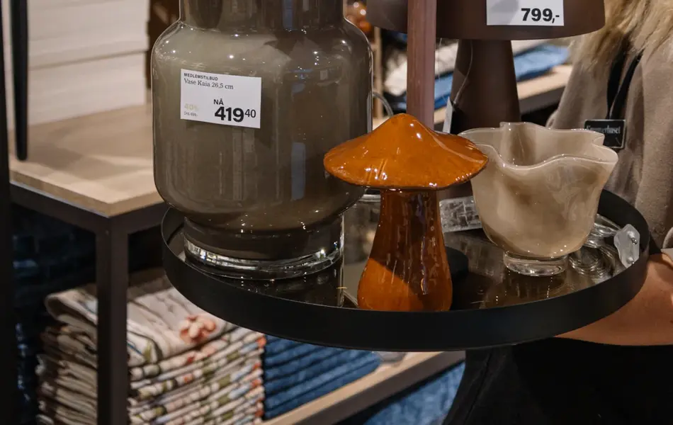 dame holder frem interiør i butikk